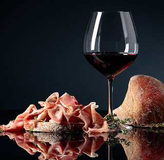 Verre de vin rouge avec de la charcuterie et du pain